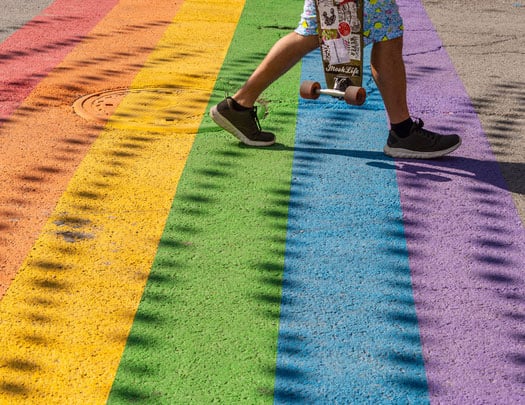Rainbow path and skateboarder carrying board